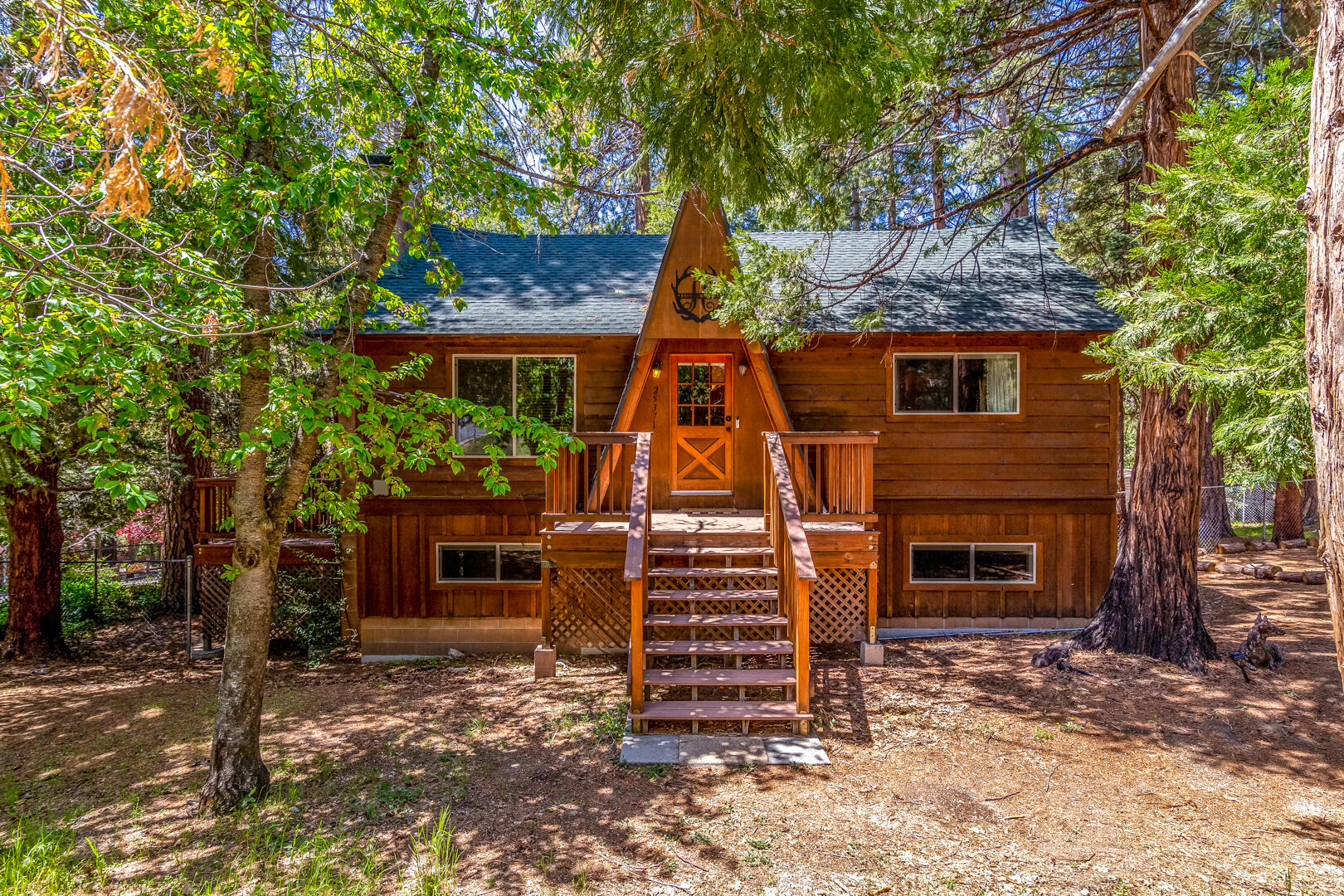 Beautifully updated TURN-KEY cabin, corner lot, in the prime location of Fern Valley. This cabin sits on 1/3 of an acre with ample space for RV/boat parking. 4-bedroom 2-bathroom home offers over 2,000 sq feet of living space. From the moment you walk in you are greeted by a large living room with stunning rock fireplace, new flooring and gourmet kitchen recently remodeled with granite counter tops, large island, wood stove & more. The kitchen flows nicely into the formal dining, large enough to seat the entire family. The wrap around composite deck can be accessed from the kitchen/family room or the dining room. Incredible views from the deck doubling as the indoor/outdoor living concept we love! First level of the home has the Primary bedroom and a full bathroom. Downstairs, offers a second fireplace, spacious living room, 3 additional bedrooms and 3/4 bath. The options for the place are endless. The lower level has its own private entrance. Use them both as two separate short-term rentals. Live in one rent out the other. Owner has installed new HVAC system, added a large driveway, and furnished this home to sleep 12 people comfortably. This cabin is less than a mile from town!