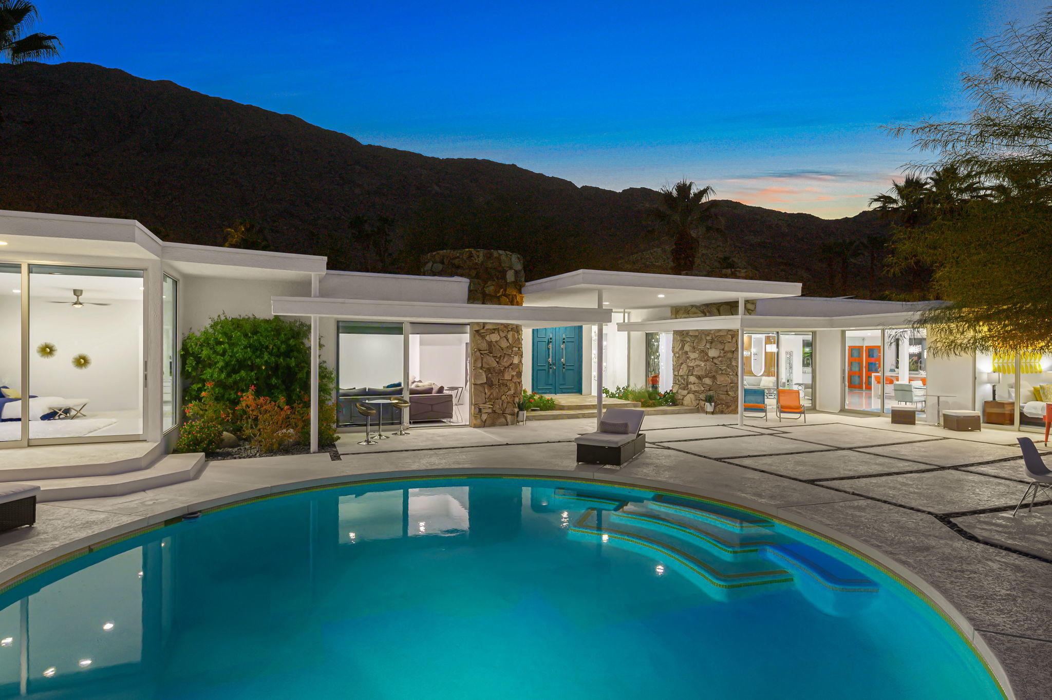 In a word, Fabulous! The Palm Springs' Gala House, enviably known as much for its enduring Mid-Century Modern style as the setting for magnificent events, fund-raisers and soirees, is now for sale turnkey furnished! Virtually invisible from the street and walking distance to the center of Palm Springs the sprawling single-level estate is located in the Historic Tennis Club. This incredible enclave showcases a down-to-the-studs remodel that retains its original architectural flair and complements it with state-of-the-art finishes, fixtures and systems. A bright orange gate opens to reveal the home's private grounds, which measure .33 acres and display a circular swimming pool. Approx. 4,825 s.f., the 5-bedroom, 4-bath design features a large living room with original stone fireplace, a stunning waterfall island kitchen with custom glossy orange and white soft-close cabinetry and a Bertazzoni range, a pool-view media room, and a grand master suite with sitting room and a glamourous bath. Powered by an owned solar system, the chic residence displays double entry doors in aqua, walls of glass, high ceilings, polished tile floors throughout, custom lighting fixtures, reversed archways, and seamless mirrored walls in key locations.  Property is also available for lease.  Ask us for details.