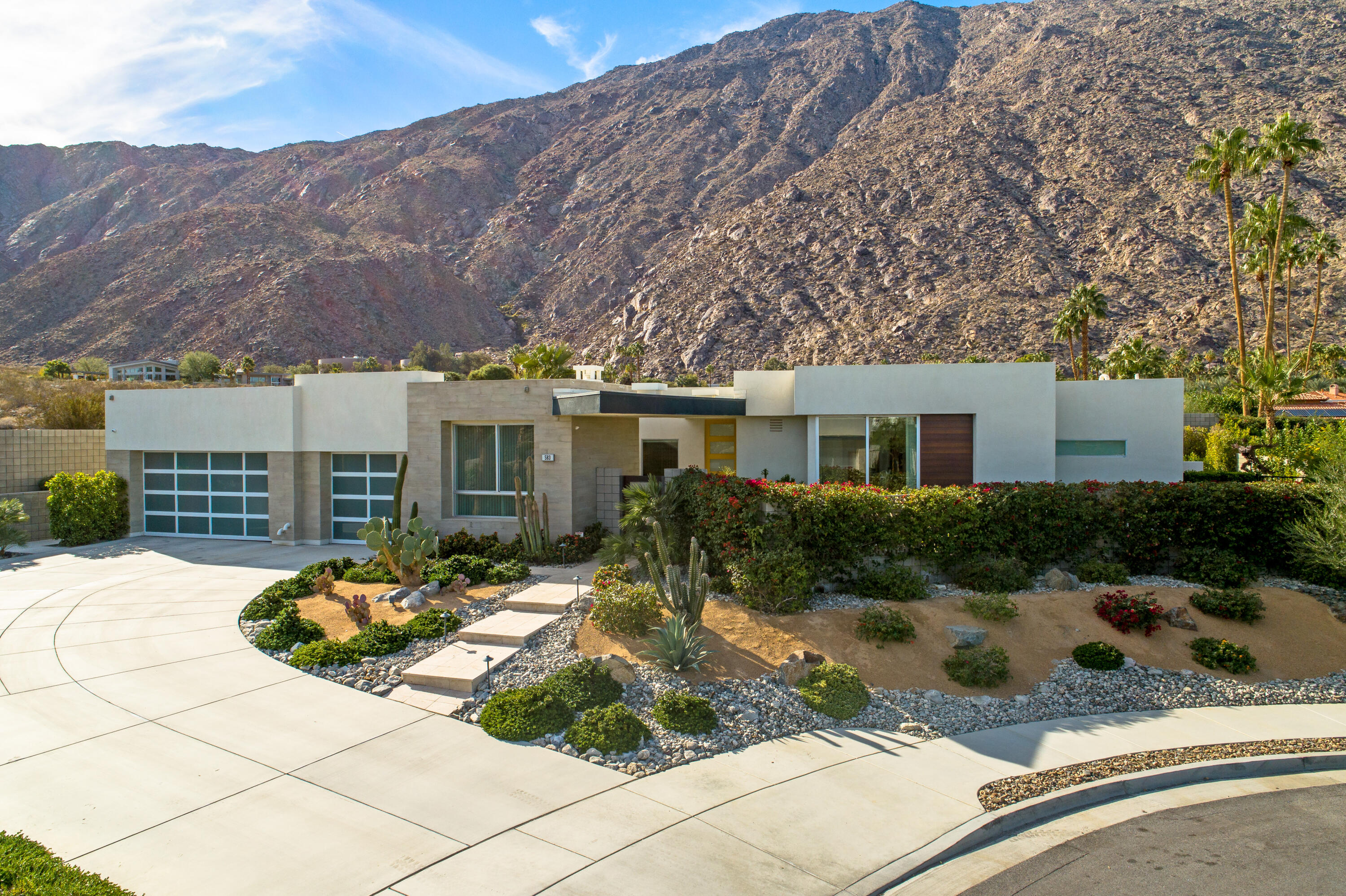 Experience stellar views from this custom contemporary home in the stunning South Palm Springs community of Skye. Surrounded by the dramatic backdrop of the San Jacinto Mountains and situated on a generous .35 AC lot, this 4 bedroom, casita included, 5 bathroom residence offers a spacious and well-designed floor plan with luxury finishes. Enjoy the finest gourmet chef's kitchen with Jenn-Air appliances plus an expansive food-prep ready island with waterfall quartz countertop. A custom floating onyx hearth spans the length of the living room wall beneath the fireplace, adding a dramatic statement to the space. Warmth, comfort and luxury are yours in the primary suite with its spa-like bath showcasing a freestanding soaking tub. The mountain views from the rear wall of glass are framed by the architecturally significant curve of the structure's roofline. A multitude of indoor/outdoor seating spaces exist to enjoy the idyllic views; whether it be from your Primary Suite, poolside or basking in the glow of the Roger Hopkins fire pit, you can't help experience the pure essence of desert living. The 1BD, 1 BA casita w/mini-fridge and sink offers privacy for guests, or solitude for self. Hardscape and landscape were designed and  customized by Sellers and include specimen plants, travertine pavers set in sand, plus full irrigation and exterior lighting. This exquisite home encompasses all of the finest qualities that living in Palm Springs has to offer. Walk to downtown.