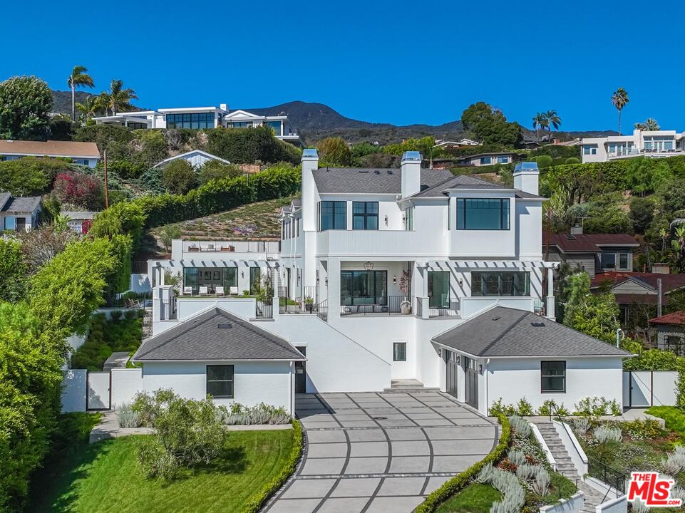 Set upon almost an acre of park-like land in the Pacific Palisades, this newly constructed estate evokes grand, traditional charm, coupled with contemporary flair, and an unmatched indoor-outdoor California living experience. Envisioned by the city's premier luxury development group, Palisades Development Company, this masterpiece offers elevated design sensibility and high-end amenities in an unparalleled ocean view setting. A long private driveway leads to your deluxe motor court and elevated glass front door, welcoming you to the ultimate entertainment compound. Open, sun drenched living spaces, ground-to-ceiling doors, french oak floors, and imported designer finishes encompass a purposeful layout with 11-foot ceilings throughout. A state-of-the-art chef's kitchen with an attached butlers pantry, a designer office, temperature-controlled wine cellar, cabana, and wellness studio equipped with an infrared sauna and steam shower, sums up the main level and allows a seamless flow to the outside oasis from any room. Upstairs, an elegant primary suite showcases vaulted ceilings, a balcony, fireplace, two expansive closets, spa baths, and panoramic ocean views. In total, 7 bedrooms, 12 baths, and all of today's necessities such as an elevator, two sets of laundry units, a four-car garage, an impressive lower level with an oversize theater, gym, and extra guest quarters complete this masterfully crafted home. Enjoy multi-leveled deck space, a heated pool, a sprawling hillside, containing a variety of trees, producing seasonal vegetables, fruits, and herbs, al fresco dining, and a lounge area with an outdoor fireplace as the sun sets. Truly a one-of-a-kind property in a highly desired location close to hiking, shopping, beach living, and all the Palisades community has to offer.