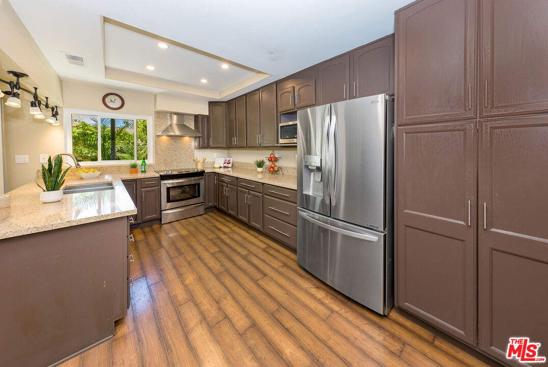23419 Avenida Rotella Valencia, California New Price To Sell! A rare single-story remodeled home on a quiet larger lot that has vaulted ceilings in the living/family rooms and bedrooms. At 2,040/sf, there are 4 bedrooms, 3 full baths and the home was expanded, remodeled and features a large luminous family room with skylights and dual-pane siders leading to the pergola/patio with fruit trees and a beautifully landscaped backyard. The remodeled kitchen is spacious with a breakfast bar and newer quartz counters - perfect for hosting friends. The Primary Suite is spacious with a dual vanity, plus there's another En-Suite bedroom/bath for guests and a separate laundry room. Very close to schools, parks, paseos trails, grocery stores, restaurants, Starbucks, and many other stores. This neighborhood belongs to one of the best HOA's in Santa Clarita "Old Orchard I" and just moments away there are two pools, barbecues, basketball court, and the clubhouse for entertainment, so it feels like a resort. Low HOA dues at $46 per month, billed simi-annually at $275 and No Mello-Roos!
