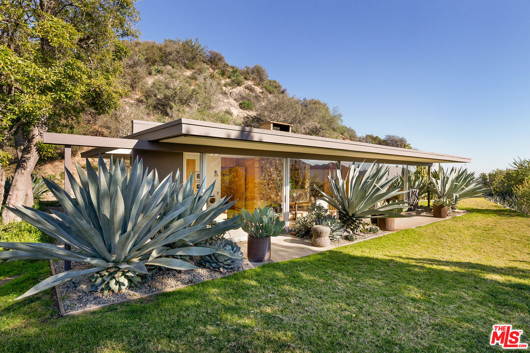 Exceptional Architectural compound offering total hilltop privacy.  This stunning pair of pedigreed properties occupy an extraordinary  5.7 acre curated succulent garden. The original structure was built by Richard Neutra FAIA for his secretary, Dorothy Serulnic, in 1953.  The 1,350 sq ft floor plan features 2 bedrooms, one bath, walls of glass, a bear valley stone fireplace and a plethora of Neutra designed built-ins, including a sofa system with record player and concealed speakers, multiple desks, shelving systems, dining room table, sliding breakfast nook and vanity.  This pristine architectural masterpiece opens to a flat grassy pad with spectacular mountain and city skyline views throughout. Nearly a half a century later, award winning architect Michael Maltzan was commissioned to build the main residence. His unique design is anchored by a 7 sided structure with an interior courtyard.  A sensational 875 ft addition was completed by the noteworthy architect in 2021. The entire structure has breathtaking mountain and city skyline views.  The heavenly primary suite with curvilinear penny tiled bathroom looks through the courtyard and onto the dramatic view. There is a smart office area, cozy den, and a multitude of built-in storage throughout.  The  enormous  Johnston Vidal lap pool is 50'long. The outdoor movie pavilion with wind screen and catering kitchen is the perfect place to entertain. A  unique cabin designed and built by artist Peter Staley completes the unique compound.  Just minutes away from DTLA, Pasadena, Los Feliz and Silver Lake, this special compound offers peace and privacy like no other.