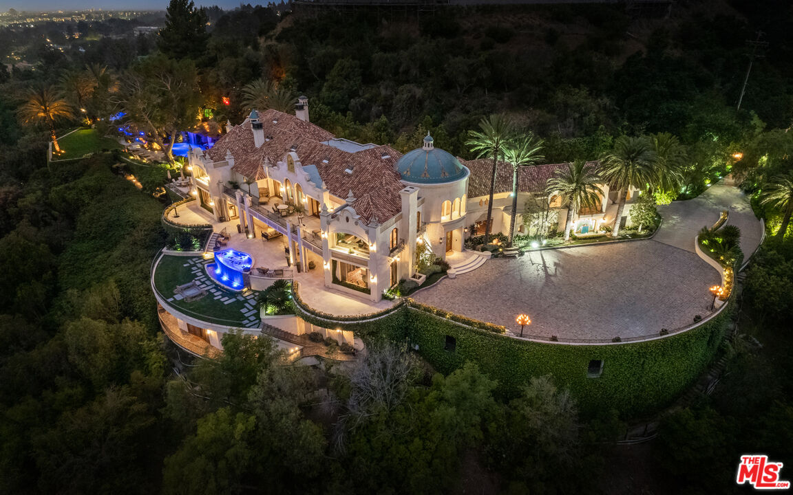 Exuding opulence, this ultra private palatial masterpiece, The Cielo Estate, is set behind large double gates with a stone motor court. Boasting 21,000sf and set on 3.6 acres and showcasing unparalleled luxury in the most desirable zip code in the world, this Andalusian-style estate is in a league of its own. The Cielo Estate is created for exquisite living & entertaining on a grand scale with 9 bedrooms + 18 bathrooms. Enter the residence through the grand front doors into the 2-story foyer with a custom staircase and custom dome ceiling. Offering a detached guest house, large living spaces, and endless amenities that display the explosive city and ocean views. The luxurious living spaces include a movie theatre, spa, gym, hair salon, billiards room, and bar. Surrounded by jetliner views, lush greenery and manicured landscaping, this outdoor space is like no other. Showcasing a 75-yard pool with 3 waterfalls, 2 jacuzzis, a 35-foot water slide, swim-up bar, private grotto, koi pond, lazy river, multiple lounge areas, cabana, fire features, and a BBQ this is an entertainer's dream. With an underground garage that can host up to 16 cars, the Estate can accommodate up to 35 cars. The Cielo estate is the epitome of world class Beverly Hills luxury living.