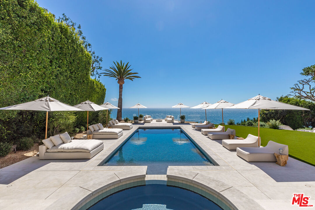 Introducing Villa Sole, a private ocean view retreat on the prized Malibu Bluffs. Recently completed in 2022, this one-of-a-kind estate has been fully reimagined by renowned celebrity designer Malgosia Migdal and noteworthy Fun-Bu Developers. Arrive to the blufftop estate through privacy enhancing gates, which reveal mature landscaping and an expansive flat lawn with a guest house featuring two bedrooms, two baths, a full kitchen and private patio. Adjacent is a private lighted north-south facing tennis court and an exterior limestone loggia. The long driveway leads to an impressive motor court, which presents the single-level main estate. Enter through the impressive tailored pivot door and be greeted immediately with the breathtaking ocean views. The great room, living room and dining room all feature 10 to 14-foot ceilings, European plaster walls, French white oak wide plank floors, trimless LED recessed lights and various high-end New York-made interior lighting designs, which are attentively integrated throughout the estate's interior. The oceanview dining room also overlooks the impressive wine cellar. The kitchen is replete with leather finish stone countertops, sequence-matched rift-cut white oak cabinetry, Miele appliances and full-height wall with a natural stone backsplash with floating shelves. Relax and enjoy an oceanfront den with a bar, which can easily be transformed into a guest room. Adjacent, the ocean view primary suite boasts a custom-built three-dimensional plaster wall headboard, spacious dual walk-in-closets, luxurious custom-built bathrooms featuring custom white oak cabinetry and European plumbing fixtures. The primary wing of the house also includes a bedroom suite with its own entrance to the outside and space for an office or gym. The fourth bedroom in the main house faces a lovely courtyard. Impressive home theater, sound and security system, top of the line HVAC units with multiple zones and trimless vents. Above the home theater is an attached 2 bedroom guest suite with its own entrance. The main home opens to a divine, resort-like backyard with an oversized pool featuring handmade tile, a Jacuzzi, exterior bar, pizza oven, built-in gas BBQ and custom built circular fire pit. Villa Sole's incredible location allows you to wake up to the sound of crashing waves and see pods of dolphins migrating at sunset. The landscaping includes a citrus grove and over a dozen mature olive, coral, ficus and palm trees. Villa Sole enjoys a prime Malibu location in the ''Celebrity Bluff Row'' section above Malibu Road, commanding approximately 1.55 acres. Located moments from Nobu, Soho House, Malibu Pier and world-class beaches and hiking trails.