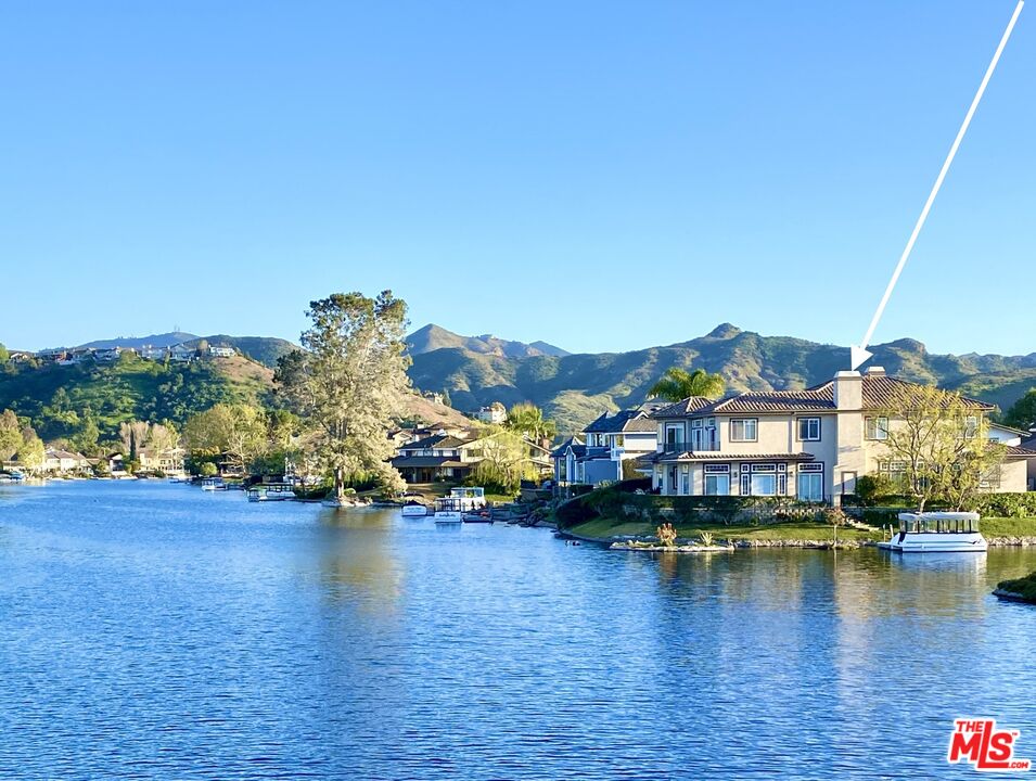 The Island, in Westlake Village, exclusive community has guard gated bridge access. This Home is on a larger prime main channel corner lot with lake and mountain views. Available Immediately. Dramatic spacious entry opens to stunning lake views. This home has an open concept, with an abundance of natural light, and an Elevator.! Upstairs Primary Suite has a walk in closet, separate shower and bath, and a large balcony to enjoy the lake and mountain views. The downstairs Primary Suite, with fireplace, lake views, and bathroom: features two sinks, separate shower, a spa tub, and walk-in closet. There are 2 additional ensuite bedrooms upstairs, and a bedroom for an office/gym with panoramic views (this room has no closet, see agent remarks). Kitchen has center island, Viking range, and refrigerator. The dining area is part of the sun-filled family room, to enjoy the sweeping views and a cozy fireplace. There is wood paneled office/study downstairs, with fireplace. Fabulous outdoor wrap-around entertaining area for relaxing, BBQ, an to dine al fresco. Grassy side yard and a lemon tree. Attached Garage. Ultimate California lifestyle. Private boat dock. The electric boat is available to transfer separately. Seller will also consider leasing the property, call Listing Agents for more information.