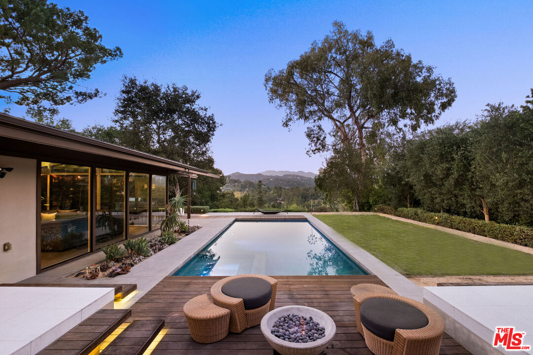 1161 Romney Dr Pasadena, California The Saltman Residence, 1962. Built by Buff and Hensman and thoughtfully restored and updated by the current owners this quintessential California home has all the character of a Post and Beam with today's modern conveniences. After ascending the long gated driveway you'll be greeted by a gracious entry, replete with a koi pond, and immediately be taken with walls of glass looking out to your refreshing salt water pool. The beautiful kitchen features custom walnut cabinetry, caesar stone island and counters, a Wolf Stove and Sub-Zero refrigerator. The spacious primary suite has dual closets, heated bathroom floors and enviable bathtub views! You'll appreciate 3 additional bedrooms as well as a TV room added by Buff and Hensman. The step-down living room harkens back to a time when people enjoyed relaxing, visiting and talking with one another. Light and bright with 20+ skylights updates also include an insulated roof, dual paned windows, solar heating for the pool, high velocity HVAC with 3 zones and a Tesla charger. This is an entertainer's dream home with incredible indoor/outdoor flow, Sonos sound system with Niles speakers, a built-in Lynx's BBQ, lovely hillside views and a wonderful feeling of privacy. With attention to detail and respect for the original architecture the owners have created a comfortable peaceful refuge in a convenient easy location. A rare pedigree offering with elegant beauty.