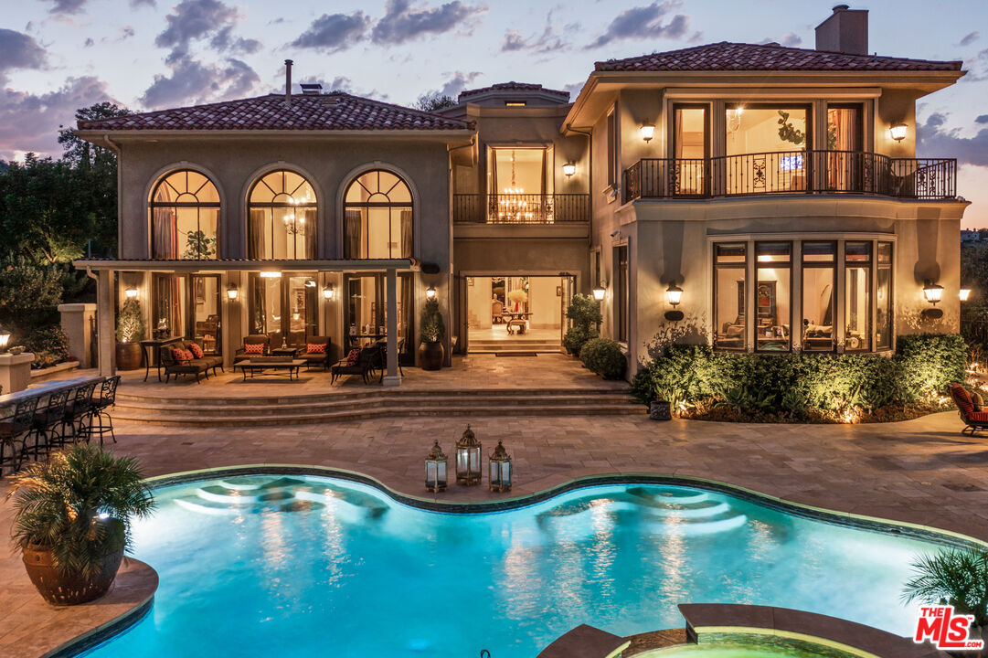 24903 Ariella Dr Calabasas, California An extraordinary opportunity of remarkable bespoke pedigree. The crown jewel of Calabasas Park Estates - The Gates at Ariella. Over 7200 square feet of custom timelessness, tailored with a distinguished degree of quality perched on a private promontory of unprecedented views. Five generously scaled bedrooms and six baths. The Primary Suite commands the pinnacle of high altitude panoramic viewpoint. Abundantly scaled, the primary features a large living space, beautiful primary spa and custom walk in boutique showcase closet. The foyer entry beams through the towered ceilings and opens vastly to all the beautiful living areas. The living room is palatial, soaring ceilings, large precast fireplace focal, full wall window and French door accent. The family room is inviting, step in bar entertainment, luxurious and comfortable overlooking the beautiful grounds. The chef's kitchen is warm and stylish, beautiful custom finishes, breakfast dinette and opens to a bistro patio. A custom built wine storage and tasting room finished with modern lit onyx accents and custom paneled doors. A car lovers delight. 4 bay garage with two custom car lifts. The unique grounds are an entertainers escape. Multiple seating areas including a patio casita with built in heaters, a stand alone outdoor kitchen with top grade built ins and amenities, beautiful mood lighting and theatrical sound system throughout for the ultimate in social gatherings and enjoyment. All set behind its own privately gated flag lot behind the guard gates at Calabasas Park Estates, a culmination of custom tailored opulence.