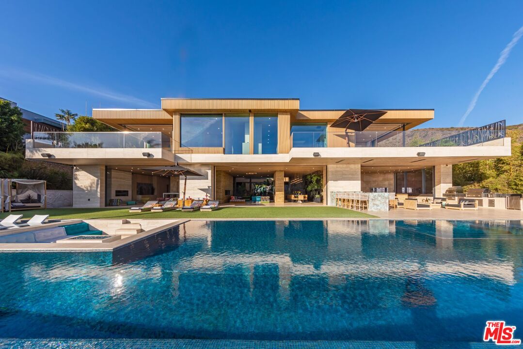 Modern Zen Malibu compound featuring approx. 20,000+ SF of living space boasting a magnificent 95' tiled infinity pool with panoramic, unobstructed views of the Pacific. Built in 2022 by MKH Developments and set behind a gated drive for ultimate privacy. This eclectic masterpiece was influenced by ancient civilizations which ultimately created a sanctuary that lives up to its name, The Kaizen Home, which is the Japanese word for the pursuit of perfection. Every single aspect of this home, from the architecture and interior design to the landscape and water features was meticulously planned to incorporate Feng Shui. The entire home was constructed from concrete utilizing floor-to-ceiling frameless glass from Germany and the exterior is layered in travertine, composite wood, and carved stone to create a one-of-a-kind home that was built to last. Custom designed details throughout the home include hand-carved stone and wood walls throughout, 2,000 gallon aquarium, backlit Onyx , live walls and a Dolby Atmos home theater. This home offers 6 BD, each with their own private outdoor terrace as well as 2 spacious 4 car garages with electric car charging and ample parking for guests. Set in Malibu, just across the PCH from County Line Beach and minutes from Trancas Canyon and Zuma Beach.