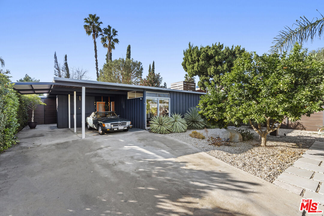 This quintessential Mid-Century Modern home designed by renowned LA architect, Edward Fickett is a hidden gem that is an entertainer's dream.  The home has been lovingly preserved, showcasing its classic mid-century lines and its original features, which are displayed throughout the home.  A highlight of the home is the original warm rich Redwood ceiling that runs throughout the home and the overhanging eaves. Large original oversized windows throughout the home let in lots of natural light and bring the outside in with refurbished transom windows.  The entertainment patio has ample space for an outside kitchen, a dining area for 12, and a cozy seating area.  The outside of the home has been fully enclosed with complimentary modern designed fencing, with electric gate entry, providing plenty of secure off-street parking with attached carport parking for 2 cars.  Both front and back grounds have been converted to drought-tolerant landscaping on a drip watering system.  Enjoy your relaxing oasis, by reading a book in the oversize cabana and deck, or in the 6-person hot tub, while enjoying a cocktail with fresh citrus provided by the Meyer Lemon, Bear Lime, and Blood Orange trees.  Upgraded plumbing, electrical wiring & low flush toilets.  New electrical 220 and 120 electrical panel upgrades front and back of the home.  The bonus room provides a separate office space, gym, or multi-use space, complete with power, a/c, and floor-to-ceiling windows.  The home is a smart home, with water fountains being controlled by a press of a button, and Nest system.  3 beds, 2 fully renovated baths, side by side washer/dryer, central a/c with additional mini splits in the bedrooms for maximum energy efficiency, and an updated kitchen.  This is the perfect So-Cal living home for those who love to entertain and are looking for a quiet oasis escape and is a must-see.