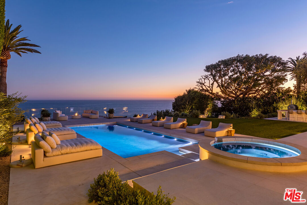 Introducing Villa Sole, a private ocean view retreat on the prized Malibu Bluffs. Recently completed in 2022, this one-of-a-kind estate has been fully reimagined by renowned celebrity designer Malgosia Migdal and noteworthy Fun-Bu Developers. Arrive to the blufftop estate through privacy enhancing gates, which reveal mature landscaping and an expansive flat lawn with a guest house featuring two bedrooms, two baths, a full kitchen and private patio. Adjacent is a private lighted north-south facing tennis court and an exterior limestone loggia. The long driveway leads to an impressive motor court, which presents the single-level main estate. Enter through the impressive tailored pivot door and be greeted immediately with the breathtaking ocean views. The great room, living room and dining room all feature 10 to 14-foot ceilings, European plaster walls, French white oak wide plank floors, trimless LED recessed lights and various high-end New York-made interior lighting designs, which are attentively integrated throughout the estate's interior. The oceanview dining room also overlooks the impressive wine cellar. The kitchen is replete with leather finish stone countertops, sequence-matched rift-cut white oak cabinetry, Miele appliances and full-height wall with a natural stone backsplash with floating shelves. The ocean view primary suite boasts a custom-built three-dimensional plaster wall headboard, spacious dual walk-in-closets, luxurious custom-built bathrooms featuring custom white oak cabinetry and European plumbing fixtures. The primary wing of the house also includes a bedroom suite with its own entrance to the outside and space for an office or gym. Relax and enjoy an oceanfront bedroom with a bar, which can easily be transformed into a den. The fourth bedroom in the main house faces a lovely courtyard. Impressive home theater, sound and security system, top of the line HVAC units with multiple zones and trimless vents. Above the home theater is an attached 2 bedroom guest suite with its own entrance. The main home opens to a divine, resort-like backyard with an oversized pool featuring handmade tile, a Jacuzzi, exterior bar, pizza oven, built-in gas BBQ and custom built circular fire pit. Villa Sole's incredible location allows you to wake up to the sound of crashing waves and see pods of dolphins migrating at sunset. The landscaping includes a citrus grove and over a dozen mature olive, coral, ficus and palm trees. Villa Sole enjoys a prime Malibu location in the ''Celebrity Bluff Row'' section above Malibu Road, commanding approximately 1.55 acres. Located moments from Nobu, Soho House, Malibu Pier and world-class beaches and hiking trails.