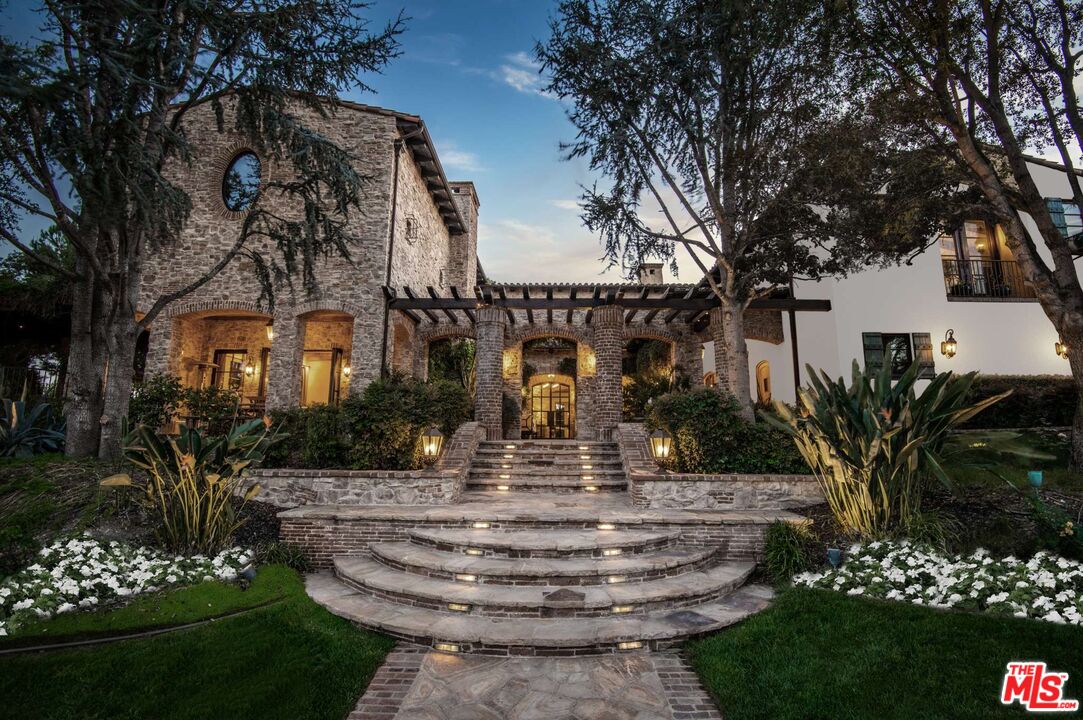 This refreshed Tuscan Farmhouse, Villa Serenia, sits behind the exclusive double guard gated Estates of The Oaks, a gated enclave in Calabasas that has attracted celebrities and VIPs in the arts, music, and entertainment industries.The only estate available for sale that overlooks The Malibu Canyon, which is part of the protected Santa Monica Mountains Conservancy, making it a true trophy property.  Old World craftsmanship combines with meticulous design elements that will delight the most sophisticated buyer. The Estate features over 13,000 square feet which has been meticulously crafted with form and function in mind. A chef's kitchen boasts a wood-beamed ceiling, dual islands, custom pizza oven, and butler's pantry. Choose to dine in either the sunlit grand formal dining room or under the picturesque trellis loggia set amongst the European gardens. One of two primary retreats features captivating panoramic views of the Santa Monica Mountains with access to a private terrace & fireplace. A secret office hidden behind a bookshelf features a 200-year-old 12 ft. beamed ceiling, fireplace & multiple doors leading to a private terrace. Property features 4 additional en- suite bedrooms that open to exterior gardens & water features. Lower-level includes a state-of-the-art 15 seat home theater & concession bar, wine tasting room and 800 bottle temperature-controlled wine cellar. Bonus features include: 500-gallon saltwater aquarium, a massage room and library with fireplace. Exterior is complete with European resort pool & spa, detached guest house, outdoor kitchen & large waterfall with koi pond. The car enthusiast gallery garage accommodates up to 6 vehicles plus an additional 2 car garage with lifts.  The estate's exceptional and rare ridgeline offers some of the best vistas in all of Calabasas. The neighborhood, which offers quick access to downtown Los Angeles, Malibu, Burbank, and Beverly Hills, is a place "where children can bike and walk around safely, neighbors are friendly, and there is a strong sense of community.  Community amenities include weekly farmers market, Olympic size pool & fitness center, tennis courts, 24/7 security with guard gate, which many refer to as "paparazzi proof." Unmatched and incomparable - The Villa SereniaSecure your spot in the last of the sought-after view lots in The Estates and treat yourself to the elegant life you deserve.