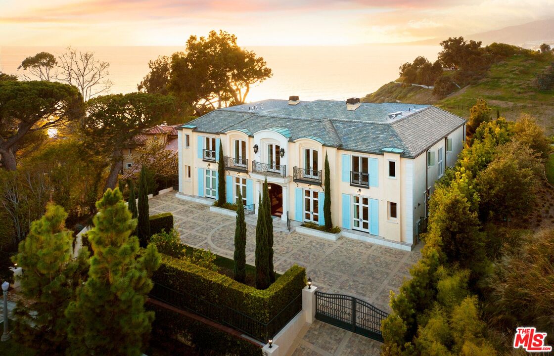 One-of-a-kind estate, located on the Huntington Bluffs offers breathtaking ocean views and has a European sensibility that is both iconic and beautiful. Upon entering the grand foyer, you are greeted by a spacious and open living area with a grand entry and nearly 25' ceiling, offering unobstructed, panoramic ocean views. The attention to detail in this beautifully crafted home is evident throughout, with most rooms boasting nearly 12' ceilings and stunning views. The primary suite features a sitting room, a large balcony and a fireplace. Additionally, a dual suite is located upstairs, and a suite downstairs provides ample space for guests or family. Walnut wood flooring, a library, seven fireplaces, a control access elevator and custom chandeliers are just a few of the luxurious touches that make this home truly special. The spa-like bathrooms feature rare marble and the outdoor space is equally impressive with a firepit, pool and spa. The landscaping includes trellised grape, citrus, and stone fruit trees, adding to the property's serene and peaceful atmosphere. The lower level has a wine room, a massive garage with six individual or numerous tandem parking spaces, and storage closets.