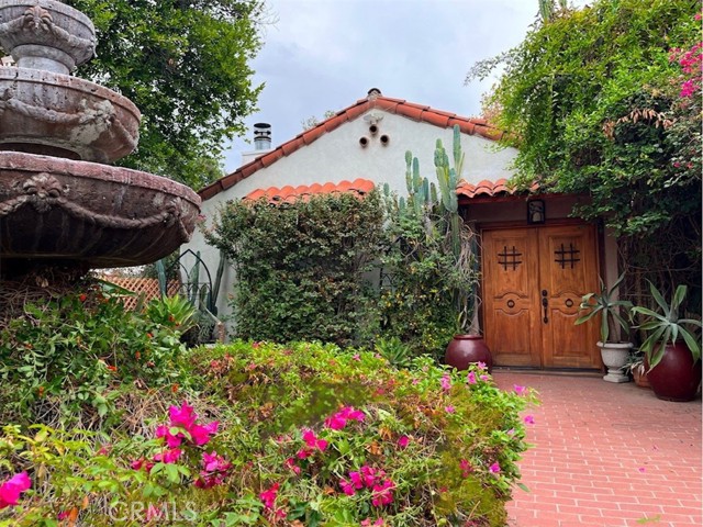 This classic Spanish mission-style property, a distinctive 'artist home , offers three bedrooms, three bathrooms, and a hearty amount of charm! Before entering, notice the red-tiled roof and a brick-paved front yard. A formal entryway opens via a sunroom with French doors, to a large living room featuring a beamed ceiling, a fireplace with two unique original built-in writing desks, and focal windows. Original hardwood flooring, coved ceilings, plantation shutters, and soothing wall colors are found in nearly every room. The formal dining room connects to both, the living room and the kitchen. A long hallway with a convenient linen closet leads to the three bedrooms and three baths. The master bedroom and bath include a walk-in closet and French doors leading to the back porch. The second bedroom features a private bath, an original cedar closet and direct access to the back porch and backyard, as well. The third bedroom with two large windows to the side of the house has access to the full bath located in the hallway. The modernized kitchen includes a breakfast nook area highlighted by two original built-in corner cabinets and offers a double sink, dishwasher, nice cabinetry, a laundry area, and direct access to your own personal California basement. A nearby door offers access to a romantic and private backyard. The spacious exterior grounds are completed with an  entertaining  deck, multiple fruit trees, a separate artist studio and a beautiful one-bedroom guest house with double entry, full kitchen, and bathroom. Located within just minutes from the famous Westfield Topanga & The Village shopping center. This is a UNIQUE opportunity NOT to be missed!