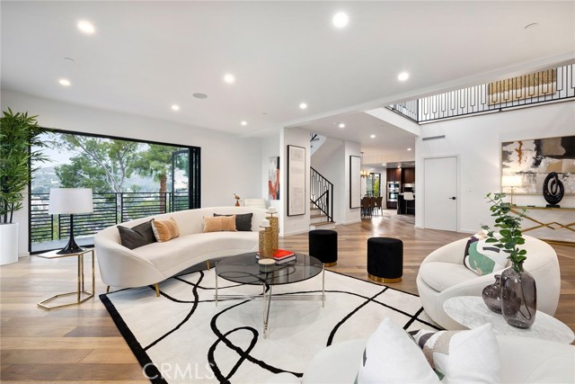 The epitome of contemporary Los Angeles living, this sleek four-level home has 180° panoramic views from each of its 4 balconies. Leaded glass double doors open to the main floor with a 2 story entry open to the floor above. Hardwood floors with a perfectly matched center seam point to a light and bright open living room with fireplace to the left, and kitchen with dining area to the right. Black wrought iron railings on the second floor landing and the balconies frame spectacular views to downtown Los Angeles and beyond. Gorgeous marble porcelain covers the waterfall center island, as well as the counters and back splash. Unique, custom-made wood kitchen cabinets, high-end stainless-steel appliances, laundry cabinet, a huge pantry, powder room, formal dining area, and spacious balcony to enjoy morning coffee, make the modern kitchen perfect. One bedroom and full bath on the main level add comfort and convenience for guests and extended family. Upstairs, private quarters include three en-suite bedrooms with private baths. The two primary suites have balconies, huge walk-in closets and absolutely beautiful bathrooms with dual vanities, glass enclosed showers and stand alone tubs.   The game room, family room and office are one level below the main floor. A wet bar in the family room has a stunning counter, and sliding glass barn doors open to a spacious office with an adjacent storage room.   More amenities on the lower floor include a home theater, yoga room, sauna, and full bath. The viewing deck and secret wine cellar offer exceptional opportunities for relaxation!