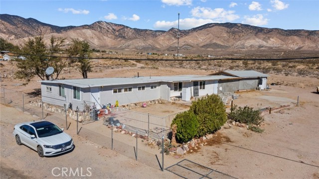 Desert mountain views, private and peaceful, this 1.32 acre property offers great potential! Located in the outskirts of Mojave, this home offers 2-units, a front and back with plenty of parking spaces, and a security fence around the perimeter. Each unit is 2-bedrooms, 1-bathroom, and 1,057 SqFt. The first unit has been recently remodeled with new tile and laminate floors, a new AC unit, and clean, new paint. There are beamed ceilings and arched walls adding nice architectural details to the interior of the home. A cozy kitchen with double-basin sink, and ample cabinet space. Unfinished rooms in the house provide endless possibilities in design and style. The yard has been cleared and is mostly flat, expanding out towards the desert with local shrubs and nature. Off the 58-Hwy on a quiet street with a few businesses and residential properties. Only 7-miles to Mojave city center, 13-miles to California City, 20-miles to Tehachapi, 35-miles to Lancaster, and 60-miles to Bakersfield.