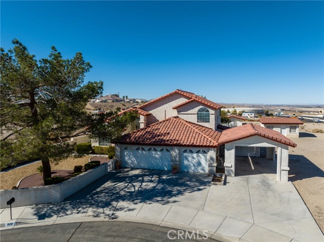Pride of ownership beams from every corner of this BEAUTIFUL custom built home, owned by its original builder! Located in a sought after neighborhood of Barstow and is surrounded by newer custom built homes on large lots! At the end of a quiet cul-de-sac with 2 APN s totaling to just shy of 2 ACRES, with incredible views! The home is greeted with an oversized driveway, meticulously kept courtyard, privacy block wall, 3 car garage, rod iron fencing, carport, exterior storage, and fully landscaped front and back yard with a timed irrigation system! The gorgeous open concept home was built with integrity and love, with vaulted ceilings, formal living room/ step down den, formal dining room, oversized kitchen with a breakfast nook over looking a large family room with custom oak built ins throughout! The main level has the living space area, 2 LARGE bedrooms with an abundance of storage and great size closets, an indoor laundry room and access to your fully finished 3 car garage! The grand staircase leads you upstairs to the MASTER SUITE! The master suite has tall ceilings, large windows and opens up to a private balcony, and resort like bathroom! The bathroom consist of a large jacuzzi soaking tub, double vanity, walk-in tile shower and WALK IN CLOSET! The home has not only a HVAC unit, but also a ducted Master Cool unit as well as PAID OFF SOLAR! As if that was not enough, the home also has 2 additional exterior buildings! One is within the perimeter of the backyard, fully finished with electricity ran to it! This room could serve as a gym, guest room, office, man cave and more! With such versatile use, this is a huge asset to the home! There is a secondary building on the exterior of the block wall that is an old home stead cabin with strong bones, with use to be a Casita! The Casita like building has private entry, and has all the plumbing in place to be converted to a secondary residence! Seller is motivated and has priced to sell!