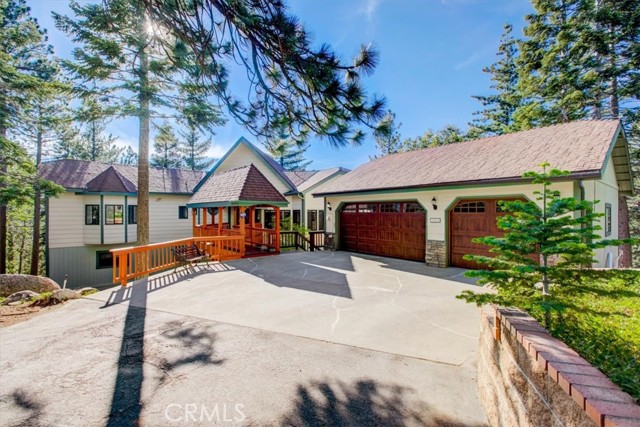 Stunning move-in-ready mountain home sitting at the end of a cul-de-sac street is ready to be made yours! The living room features gorgeous cathedral-style ceilings with wooden beams and oversized picture windows that let in an abundance of natural light. There is a floor-to-ceiling stone fireplace and a chandelier hanging in the center of the room. The kitchen has wood cabinetry with tons of storage space, a massive center island with a cooktop and utility sink. There is also an included sub-zero refrigerator, and a wine refrigerator. The formal dining room sits just off the kitchen and there is a large laundry room with additional storage space and included washer and dryer. There is an office with built-in cabinetry just off of the living room, 2 bathrooms (a half bathroom and a full-size bathroom) a bedroom, as well as a giant primary suite with private deck access, and a spa-like ensuite with dual sink vanity and soaking tub. There is also central A/C on the main floor. On the bottom floor there are 3 additional bedrooms 2 bathrooms, and a large bonus game room with a fireplace and deck access - the perfect space for entertaining! This home has an attached, level entry, oversized (896 SF) 3-car garage, outside stairs to access storage in buildup under the garage, beautiful Redwood decks on each floor with included hot tub, a European Style bridge to the front door, and stunning unobstructed panoramic mountain and forest views, sitting on an acre lot, with a private well as well as connected to public water!