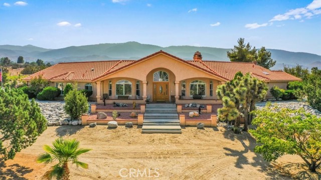 *Price Improvement* This beautiful custom home comes with a beautiful pride of ownership, built with love, quality and attention to detail. Peaceful desert living at its finest. As you pull into the gate you are greeted with a beautiful entry of mature trees and rock landscape. This beautiful 2.5 acres is fully fenced, with a solar gate, 2 central ac units, 2 hot water heaters, surround sound speakers around exterior and the entire lot is on a drip system to nurture the beautiful foliage. The front of the home offers a porch where you can enjoy the morning sunrise. As you enter the beautiful decorative front door you will see beautiful laminate wood flooring, and beautiful architecture of the design of the square, round archways and detailed tray ceilings throughout the home. There are several large windows with custom shutters throughout the home, perfect for all the natural sunlight. On those cozy nights the living room offers a natural wood fireplace with a beautiful brick and wood mantel. Off the living room is a bar with a sink, and a den that you can use as a game room for all your entertainment needs. The kitchen is a must see for the bakers and chefs out there. Let me just say lots of cabinet space and a ginormous pantry. The kitchen offers a custom 36 inch range, custom fridge, recessed lighting, beautiful tile backsplash, oak cabinets, granite counters, and open space throughout for all your cooking and entertaining needs. Perfect space near the bay window for a small dinette table to enjoy a cup of coffee as you watch the birds on the patio. All bedrooms offer carpeting, ceiling fans and shutters on windows. The master bedroom offers an electric fireplace, lots of natural light, slider off to the back patio, and walk in closet with a sky light. The master bathroom offers a dual sink vanity and large walk in shower. All bathrooms offer ADA toilets. Those nights you need to unwind the master bathroom offers a spa tub with beautiful decorative beveled glass windows to accent. The beautifully landscaped backyard is perfect for entertaining with its large covered patio. Need to break a sweat, we got you covered with the sauna. Oh, did I mention the hot tub? Last but not least the beautiful circular driveway makes it a breeze to pull into the 3 car garage or the RV Barn with roll up door, 220 volt (50 Amp) and 110 Volt (30 Amp) outlets, lots of overhead storage space that covers the perimeter and wood countertop the length of the garage.