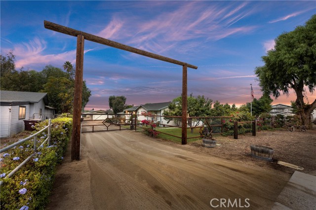 Beautiful 2.38 acre working horse ranch in the heart of Norco.  This home has everything you need to establish your boarding, breeding or training business.  To start there is a large MD barn with a 32 ft breezeway.  It has (7) 16 x 24 pipe stalls & 1 box Stalls and a 16 x 12 tackroom. Under the breezeway is a large wash rack with hot & cold water.  On the backside of the tackroom are individual tack lockers.  These tack lockers are also located over by the 12 x 24 stalls.  There are (9) 12 x 24 stalls, (7) 24 x 24 stalls.  Two long MD shelters, one is over the 24 x 24 stalls in the back end of the property & the other is large enough to cover two full loads of hay & two horse trailers.  Two round pens are at the front of the property along with a hot walker and trail course.  The arena is lighted and is north of the main Barn (120 x 60).  The 3 bedroom two bath house is spotless and you can tell it has been loved for many years.  You walk into a spacious dining room and to the left are two bedrooms and a full bath that has been updated.  The cute kitchen has new stainless steel appliances and an island.  The large family room is at the back of the house and has big windows to view the ranch from and is completed with a pot belly stove.  The oversized master bedroom is also at the far back corner with a large viewing windows that looks toward the barn area.  There is a custom attached bath with an oversized shower and large walk-in closet.  French doors lead out to a serene area with a trickling fountain that goes into a Koi pond.  There is a soothing spa in the far corner.  Out the back door is an expansive porch.  The cute guest house sits behind the main house and it has a kitchen bath and living room/bedroom combo.  Complete with its owned fenced yard.  Behind that is a large club house/saloon with a custom bar and restroom. (the restroom is also plumbed for a future shower)  Think of the parties you could have.  Can't forget to mention the one car garage and attached shop.  In the front there are numerous fruit trees and berries including avocado, apricot, lemon, navel orange fig, lime, white peach, almond and a trellis of kiwi.  By the house is a green house and chicken coop.  On the side of the house is a raised garden. A large doggie door also leads out the master to a fenced in dog run and kennel. This hidden gem is behind your own private security gate with its own keypad for entry.  This is your own private paradise that you must see!