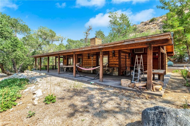 This is a once-in-a-lifetime opportunity to own a unique property located in the spectacular lush Morongo Valley Hills.  From the swing over your pond, to the trickling spring with water running in and out, this is a "one-of-a-kind" "must see"!!  This land and an 860 square foot gorgeous wood cabin home which is a single family residence is included. It is a 1 bedroom 1 1/4 bath. The 1/4 bath is set up as the laundry room with a washer/dryer hookup. The home is an open floor plan, enter into the kitchen where there's a wooden table and chairs. Next walk into the expansive living area totally furnished as well.  The only door leads into the lovely furnished bedroom. You see those wood beam ceilings they spared no expense when it came to this design all of which is wood. It's move-in ready and comes with this property. This location in the high desert commonly referred to as the Morongo Basin area is highly desirable and sought after for a place to live. Part of it's charm are these enormous trees that provide you shade, it's much cooler in the valley and the higher elevation. It is a "Preserve" and has another designation it's "conservationist" land as well. This property as it is may have federal protection as well.  There are multiple orchards, with apple, nectarines, pear, and peach trees. You will find grapes growing as well. Oh yes, let's not forget you can pick them off the tree "sugar sweet" cherries.  There's stevia and Echinacea plants, WOW! This property is paradise and has also been designated for events so go ahead have your wedding here hard to find a more beautiful location. BLM (Bureau of Land Management) wilderness land surrounds you so privacy, tranquility, and the beauty within these canyons is always yours to forever own!! The beautiful San Jacinto Mountains are the endless views that abound everywhere. This is a "must see" to believe!  You are less than a 30 minute drive into Palm Springs. It's about ten minutes in either direction to Interstate 10, so conveniently located. It's a dirt road to this property, about 2.5 miles off of Highway 62. It's easy to locate and it's also hidden, nestled in between the canyons. Do bring your imagination as obviously what you wish to do here is attainable and a dream come true!