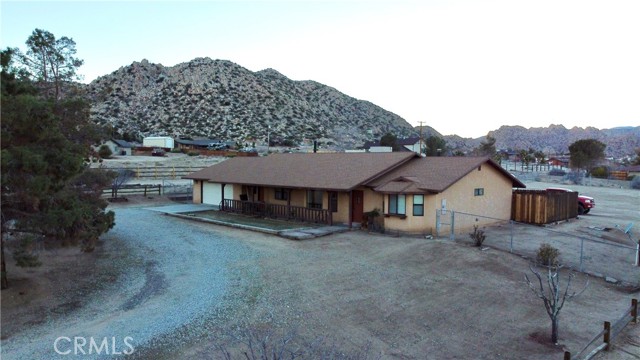 Amazing views and desirable LOCATION in the heart of Pioneertown. Walking distance to Pappy and Harrietts! This 2,017 sq. ft., 3 Bedroom, 2.5 Bath open floor plan with Spanish tiles and new carpet throughout. Master bedroom has a 2nd wood burning fireplace, walk in closet and a over 30 sq. ft. walk in shower with double shower heads and door leading to private spa area. Spacious Kitchen offers an island with an additional sink and walk-in pantry. Laundry room leads to finished 3 car tandem garage with a half bath. 1.26 acres manicured horse property with mature trees. Make this beautiful well built home your very own full time, part time or investment opportunity.