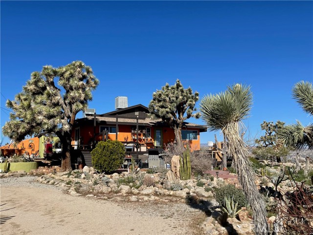 ****20 ACRES OF PARK-LIKE LAND**** Turn off the dusty road and wind your way up to this amazing home, situated on 20, private acres of Joshua Tree forest, near the national park boundary. Perched on the hill, your views go on forever, in every direction.  Sit on any of the decks and watch a chuckwalla take a sun bath. Walk along the many trails.  Hike the rocky hills. Wildlife is abundant.  The 2-bedroom, all electric home, has been modernized with new windows and doors, new appliances, waterproof cork flooring and fresh paint.  The central heating and air system is new.  The kitchen features concrete countertops and a new, induction range/oven.  The detached garage includes a home gym with an infrared sauna.  Get lost in your healthy, nature-centric living experience.