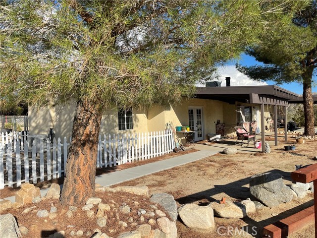 Here is an opportunity to enjoy something special on 5 acres that has been legally split into 2 lots.  Imagine the investment possibilities of these two parcels. The entire property is fenced and has a gate code and touch pad for entry.  The 500 square foot kitchen is the heartbeat of the home with soaring ceilings just under 12ft. The updated permitted kitchen includes: a 36" 5 burner gas cooktop with a pot filler, electric double ovens, an oversized walk in pantry, a wine cooler, an additional prep sink in the oversized kitchen island, and a covered patio outside the dining area to enjoy entertaining on the oversized covered porch. Two of the three bedrooms have french doors leading to their own dedicated patios to take in the views. There is a permitted 4000 square foot garage with 6" reinforced slab and 2 16x14 commercial roll up doors, and 400 amp electrical panel with 200 amp at the garage. In addition there is an RV dump station. There are two compressors, 4 energy efficient mini splits that were installed in the last 12 months, new evaporative cooler, a tack room with power and water, a hay room, a classic out building, and a large cooled and ducted dog house which is covered and gated.   With majestic Morongo Valley views and cooler temperatures, this home is less than 30 minutes to the Palm Springs International Airport, Joshua Tree National Monument, Pioneertown, and is protected by the Sand to Snow National Monument which outlines both sides of the Valley.