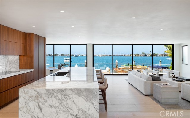 Just completed, this bay front home occupies the most sought-after location on Newport Harbor. Set behind the manned gates of Linda Isle, this 5,500 square foot residence of contemporary design is meticulously finished with the finest of interior appointments. The result is a home that is uncommonly spacious, light, and livable. Walls of floor-to-ceiling glass on both levels capture the very best uninterrupted westerly views over the main turning basin - considered to be the best on the harbor. The primary suite spans the width of the property on the second floor and features astounding views. It includes two baths and dressing areas, as well as a sitting room. Other features of the home include a two-story gallery entry, a media room, two kitchens (main and catering), a commercial elevator, and a private dock for a yacht in excess of eighty feet. This is a nearly perfect home, in a perfect location. More information is available upon request.