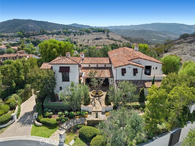 This magnificent Santa Barbara custom estate is sited at the end of a prominent cul-de-sac street with exceptional privacy and views of the treasured Shady Canyon topography with its gorgeous rolling hills and boulders. Beyond a charming courtyard, enter into the foyer gallery and to the showstopping formal great room showcasing the home s artisan quality with reclaimed beams, stone fireplace and a set of three French doors opening to the gardens and picturesque views. Just through the butlers pantry, the enormous space housing kitchen and family room has a refreshing contemporary aesthetic with white marble counter tops and white cabinets in perfect contrast to the rich hardwood flooring, beamed ceiling and recently installed modern black steel windows and doors. It provides the perfect atmosphere for cooking while socializing with friends and family in the family room or breakfast nook. French doors on one side open to a terraced outdoor dining area with fireplace and built in barbecue - and on another side to the pool and jacuzzi.  The rear yard provides an abundance of vignettes and two emerald lawns, all with tranquil views. The main level master suite encompasses an entire wing, with office, dual baths and dressing rooms, and sumptuous, master suite with vaulted ceiling adorned with beams, fireplace, and as with all of the rooms on this level - French doors to access the entertaining grounds. The second level comprises three bedroom suites   two connected via Jack and Jill bath - and large bonus room that opens to a terrace with powder room. An elevator accesses this level and also the subterranean where an impressive wine cellar and tasting room offers more opportunities to enjoy the good life. Additionally find a gym, bathroom, generous mudroom and an abundance of storage with the four-car garage on this level. Other highlights include a formal dining room, main level private guest suite, and casita. Shady Canyon offers its residents 24-hour guard gates, cycling and walking trails, tennis, sports court and swim facilities, playground and much more.