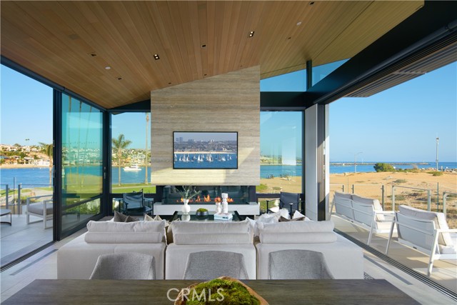 Discover an intimate living experience in harmony with the sand and sea at The Wedge House: a brand-new (2022) decadent-masterpiece flawlessly designed as an entertainer's paradise. Set on two oceanfront lots (2168 & 2172) at the end of the Balboa Peninsula, this trophy estate occupies one of the largest oceanfront homesites in coastal Orange County with a combined view frontage of appx. 140-feet. Overlooking the legendary Wedge surf break, with unbroken ocean, whitewater, beach, channel, China Cove, park, and shimmering city-light vistas, the exquisite four-bedroom, three-and-one-half-bathroom residence s smooth contemporary style reflects the efforts of revered GRAHAM Architecture and premier custom home builder Chris Gallo of Gallo Builders. A double-height foyer and custom pivoting door present the stunning interiors of appx. 3,725 SF and introduce the lower level dedicated to an office with outdoor access, an after-beach changing room with shower, and a magnificent beachfront primary suite with two walk-in closets, high-end spa-caliber bath featuring a freestanding tub and rain shower, and two sets of glass pocket doors that open to an oceanfront patio complimented by panoramic views and an open-air fireplace. Ascend to the main level by the Elevator Boutique elevator or wide custom staircase with 1"-thick glass stair rails, and find three additional bedrooms and two-and-one-half bathrooms. Floor-to-ceiling walls of glass in the living and dining areas create an on-the-water effect enhanced by slide-away glass pocket doors that open to a fireplace-warmed ocean-view deck. Vaulted hemlock wood ceilings lend architectural drama to the space and flow seamlessly onto a water-view courtyard with an outdoor kitchenette, and a sleek, modern kitchen showcasing custom cabinetry from Germany and top-tier Gaggenau appliances. A residence of this distinction deserves only the finest, and it impresses with hydronic radiant-heated floors throughout, Italian porcelain tile and white oak wood flooring, low-maintenance Caesarstone quartz countertops, Fleetwood doors and windows, Sonos speakers, J. Geiger automatic window shades, rift white oak interior doors, and a Savant whole-house smart-home system. A rare offering of two exclusive addresses, this landmark estate also comes with city and coastal development approved plans for a one-bedroom, one-bathroom guest house with a kitchen, courtyard, two-car garage, pool, and spa.