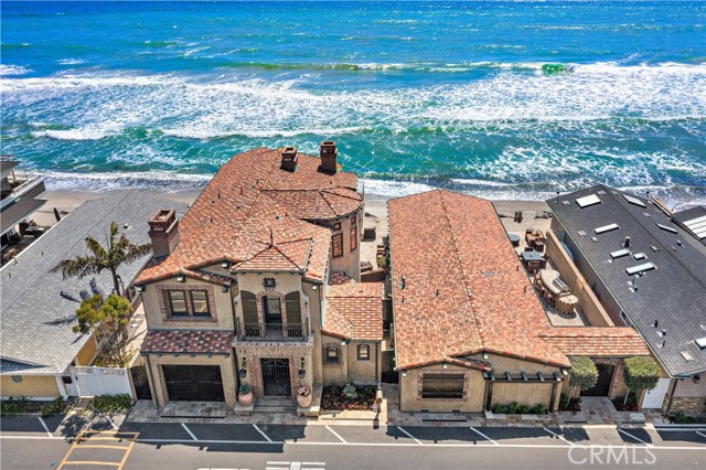 Custom luxury is elevated to impressive heights at this luxurious custom estate in the private oceanfront enclave of Capistrano Shores in northern San Clemente. Occupying a rare double homesite with nearly 80' of frontage on the sand, the property reveals two private residences including a grand two-story English manor-style home and an equally impressive single-story design. Both homes offer panoramic views that stretch from San Clemente s pier up to the Dana Point Headlands, with breaking waves, the Pacific Ocean, Catalina Island and beautiful sunsets in between. The main residence hosts a fabulous first level with high ceilings, a rotunda with circular staircase, and a great room with stately fireplace and floor-to-ceiling slide-away glass doors that open to the beach. A massive island centers the kitchen, which displays antiqued and distressed custom cabinetry, top-of-the-line appliances, a butler s pantry and granite countertops. Upstairs, the primary suite is crowned with vaulted ceilings and features an ocean-view balcony, a see-through fireplace that warms the bedroom and bath, a jetted tub, four-head shower, a secondary washer and dryer set for the ultimate in convenience, a walk-in closet, and a retreat with fireplace. The residences offer a combined total of 5 bedrooms and 6 baths in approximately 4,500 square feet, with the second home featuring a full kitchen and an open great room with stunning ocean views. Preferred appointments include whole-house heated flooring, Venetian plaster, whole-house water filtration and audio systems, handsome wood beams, exquisite tile and woodwork, motorized roller shades in the main house, automated storm shutters on beach-facing windows, two wine-storage units, multi-zone HVAC, and a garage with storage for bikes, surfboards, and a golf cart. Grounds include two private patios and a built-in barbecue island. Residents of Capistrano Shores enjoy beach living at its very best. Located between San Diego and Los Angeles, the resident-owned community of just 90 homes is sought after for its unique combination of an oceanfront setting and timeless charm. The neighborhood is just minutes from the popular Outlets at San Clemente, local parks, I-5 and excellent schools.