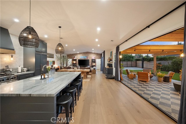 Perfectly dubbed 'Vibrant Thing', this chic and casually upscale home in Costa Mesa s preferred Eastside neighborhood reveals a complete remodel that checks all of your boxes and even a few you didn t know existed. Curb appeal is off the charts, with a contemporary horizontal-plank wood fence embracing a meticulously manicured front yard, a large synthetic-turf lawn, and a covered brick entry porch. Nearly 7,865 square feet, the large homesite continues in a spacious and private backyard with a motorized driveway gate, an oversized alley-access two-car garage with storage, a covered patio, open-air fireplace, designer tile and a half-basketball court. As if taken from the pages of an upscale architectural magazine, the warm and inviting outdoor living spaces give way to an equally fabulous interior, where a single-level floorplan reveals three bedrooms and two- and one-half baths in approximately 2,250 square feet of on-trend living. Epitomizing the home s welcoming vibe, a Dutch entry door framed by illuminating sidelites invites everyone into an open great room, dining and kitchen area with a vaulted ceiling and two sets of La Cantina accordion doors that open to the backyard. The heart of the residence is undoubtedly its designer kitchen, showcasing an island with wine storage, quartz countertops with Carrara marble subway tile backsplash, floor-to-ceiling cabinetry with soft-close doors and drawers, a pantry, built-in desk, open shelving, and Viking appliances including a six-burner range. Powered by a rooftop solar array, the exceptionally bright and vibrant home is complemented by wide-plank white oak flooring, custom built-ins, designer lighting fixtures, brick accent walls and, in the great room, a built-in wine refrigerator. The height of modern sophistication is achieved in the primary suite, where enrichments are led by French doors that open to the backyard, a walk-in closet with a sliding barn door and custom built-ins, a soaking tub, dual vanities, and a walk-in shower with sleek Clé tile and a built-in seat. Eastside Costa Mesa is sought after for its quiet streets and easy access to Newport s Back Bay, shops and restaurants along 17th Street, numerous community parks, and award-winning Newport Mesa Unified schools.