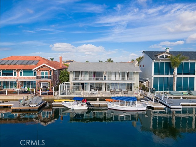 Stunning point location with 69 feet of water frontage overlooking Christiana Bay featuring some of the widest views in Huntington Harbour and the private, 65 foot dock is large enough for multiple vessels. Endless possibilities await at this amazing, end of cul-de-sac waterfront location.  The 4 bedroom mid-century modern can be remodeled to taste or build your dream home on one of the best locations in Huntington Harbour.  Approved plans for a brand new 3-story, 5000 square foot 4 Bedroom, 5 bath home are included.