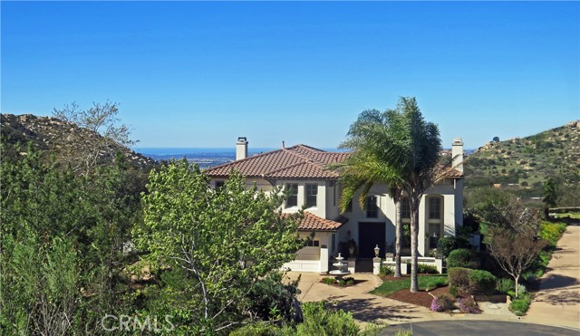 Rare find! Ocean view home in beautiful Mt. Woodson located just between Poway and Ramona! Gaze upon colorful sunsets over the Pacific Ocean every day from this high elevation executive home situated on a premium 0.38 acre lot right next to Mt. Woodson at the end of a cul-de-sac!  Surrounded on three sides by wide open natural California beauty, this home offers a unique feel of country living within a gated, well-groomed golf community.  Spacious and luxurious, this 3,023 sq ft home has 4/5 bedrooms, 3 baths, a granite kitchen, large covered patio, grand double door entry with 20 ft ceilings, a beautiful hardwood curved staircase, 2 fireplaces, large west facing picture windows, a 3 car garage, fruit trees, a large flat yard, and views galore! Hiking enthusiasts will love the easy access to the mountain trails and the nearby Ramona Grasslands, while  wine enthusiasts will delight in the close proximity to Ramona's more than 30 wineries.  Come home to Mt. Woodson, your peaceful haven away from the crowds and the traffic that is still convenient to San Diego via Scripps Poway Parkway.