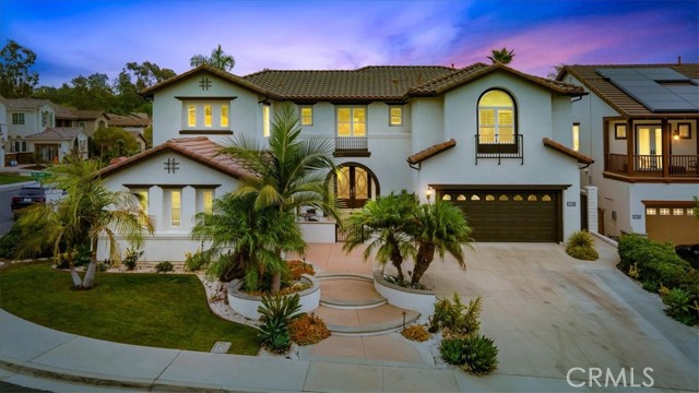 Prepare to be amazed by this centrally located spectacular Mediterranean-style estate in the private guard-gated Treviso community in the Township subdivision of Tustin Ranch. Choose to enter the home through the grand double-door entry or directly to the first-floor guest suite via the double French door entry. Once inside, you will be impressed by the large formal living space featuring soaring ceilings and a beautiful custom bar area which is excellent for entertaining large groups yet cozy enough to make small casual gatherings with family and friends just as special. Next, you will be taken by the well-situated formal dining area and the lovely ceiling accents. Around the corner is an amazing open-concept, chef s delight kitchen with Viking and Sub Zero appliances and a center island that will fit the entire family. Being adjacent to a spacious family room offering tons of natural light so you can enjoy reading a book, watching TV, or being mesmerized by the home theatre system featuring a 185-inch screen and 4k projector and its 11.1 surround sound system featuring DOLBY ATMOS. Pre-wired for full WIFI connectivity, this Smart home offers a Lutron Grafik Eye lighting system to ensure the perfect mood lighting for every occasion. Also on the first floor is a second primary bedroom, with its recently remodeled en-suite bath, plus a bonus room that can serve as a 6th bedroom, an office, or a gym and offers direct access to the lovely backyard through a private French door entryway. Upstairs you will find the gorgeous primary bedroom suite boasting a sitting room, balcony, multiple closets including a walk-in, and a spacious recently remodeled en-suite with a modern tub, a large walk-in shower, and ample vanity space. There are also three more bedrooms, a loft, a library, and the remodeled 4th and 5th bathrooms, one of which is Jack and Jill style. Outside, entertain to your heart's content in the spacious backyard, featuring multiple conversation areas, a professional BBQ Island, and a gas fire pit surrounded by a fully landscaped outdoor lounge area. Over ten mature fruit trees surround the yard s perimeter, including oranges, lemons, tangerines, plums, guava, apple, pomegranate, persimmon, and figs. An open lot with few homes around provides you with lovely hillside views. Then finally, for every golf enthusiast, the Tustin Ranch Golf Club is just a cart ride away, across the street from the entrance of this wonderful community.