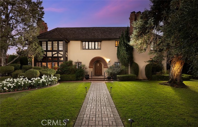 Extraordinary Moriarty Segerstrom Tudor Estate in Floral Park, built in 1929 and steeped in history! Oversized, grand rooms with elegant style, freshly refinished hardwood floors, stunning mahogany wood banisters and doors, 4 dramatic vintage fireplaces and many other architectural details from unique archways to beautiful vintage tile. Grand foyer with vaulted ceiling and reception area, along with the beautiful Tudor staircase as a focal point. Impressively large living room with Batchelder style tile fireplace, sparkling hardwood floors, stained glass, and a wall of Tudor-style, mullioned windows. Inviting den with warm wood trim, vintage tile fireplace, and a half bath. Old-fashioned, English Pub or game room with bar, archways, brick raised fireplace, and French doors to the open-air patio and huge backyard. Large, updated kitchen with a traditional walk-through butler s pantry to the dining room. Gracious dining room perfect for elegant entertaining and view of backyard. 5 spacious bedrooms and 3.5 bathrooms. Primary bedroom has Batchelder-type tiled fireplace, dual closets, and an exquisite private bathroom with clawfoot tub and large ADA compliant shower finished in marble. Downstairs bedroom with private bath. Stained and leaded glass grace multiple windows and the multitude of French mullioned windows fills the large rooms with natural light. Additional features include custom elevator, plumbing upgrades, an immense attic space with wood floors, and a cement-floor finished basement large enough for a great wine cellar! Expansive patios and backyard, perfect for dining al fresco or entertaining large parties. Approximately 100-year-old sequoias in the front yard and giant oak trees in the back along with mature landscaping on a huge over 20,000 square foot lot. 3 car garage at the end of a private, gated, long driveway. Extra parking spaces at end of driveway and possible room to expand garage behind current structure.  Historic Floral Park is a neighborhood full of vintage and historic homes with events such as the Floral Park Home & Garden Tour and neighborhood parties for the residents to enjoy, so wonderful they close down streets for snow or live entertainment! Centrally located and close to the 5, 22, and 57 freeways, it is just minutes to the Orange County School of the Arts, Shopping at Main Place Mall or the Outlets of Orange, Angel Stadium, as well as both Downtown Santa Ana and Downtown Orange.