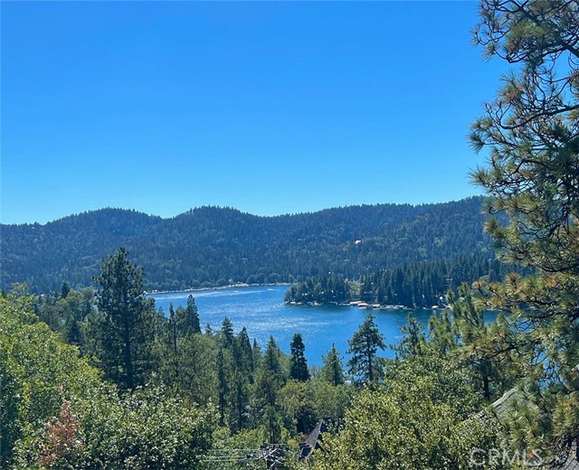 Spectacular Lake View & Half Double Dock!!  Not another one like this! Probably one of  John Radleighs best custom homes! This magnificent Lodge explodes of Mountain Character like no other! Soaring Hand Hewn Beamed Ceilings. Custom floors... Rich in Wood and Glass! Grandscale spaces for entertaining, inside and out! Breathtaking Lake Arrowhead Views! The Dining area for 10 is situated at a floor to ceiling window overlooking the lush green mountains and sparkling blue lake. This is only one of many spaces to entertain. The Chef's Dream Kitchen is wide open to the room with stone counter and Bar Chairs. Every possible kitchen amenity including Pizza Oven! The Eccentric English Bar is the focal point of the room which seats 10. Each of the 6 Bedrooms is "Designer Perfect" and there are 3 private suites. 7 total Bathrooms. Cozy Den with Fireplace. Game Room. Sweeping View Decks surround the home. Heated floors in some rooms. 3 Car Attached Garage, 2 electric car chargers. Large Gym! Private Parking. Generator powers the entire home. Central A/C. Lake Rights! Includes 1/2 Double Dock!! Dream Showing!