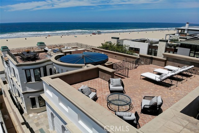This impressive oceanfront villa delivers a premium property experience crafted on a scale and magnitude that will leave you speechless with its stunning design elements. For those seeking front-and-center beachfront living but also requiring privacy, this is your Strand home. A retracting 16' atrium window opens to a very rare, practically full-length rooftop deck engineered for a future rooftop pool! The over-sized beach level patio sits below The Strand offering another great entertaining environment tucked away from passersby, yet within a few steps of the beach. There are two fully-loaded Viking outdoor kitchens - one on the beachfront patio and the other on the rooftop. Influenced by the original owner's travels throughout Italy, no expense has been spared in creating this masterful trophy home. Every fine detail and amenity has been painstakingly planned; every aspect beautifully considered. From the expansive beach level great room with an 800 gallon saltwater aquarium to the hand-carved wood floors and imported Roman marble tub, there are too many amenities and details to present in a short description! This home simply must be experienced. Fully loaded with smart-home features, elevator & dumbwaiter, theater & gym, a 5' La Cornue range, and a private master "apartment" like you've never seen! Within a stone s throw of the beach, there is easy access to the fine restaurants and the vibrant community scene found throughout North Hermosa and South Manhattan Beach.