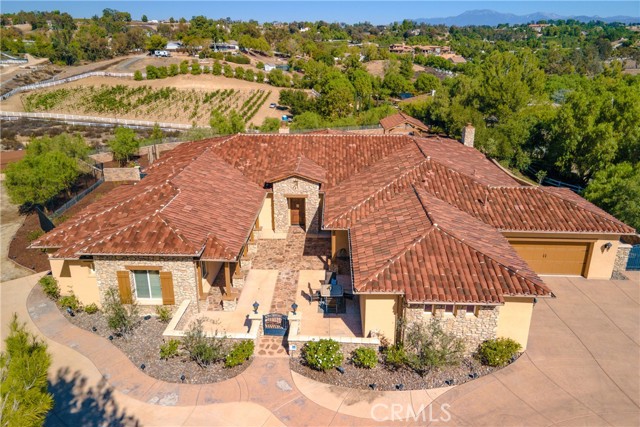 Tuscan home in the prestigious gated community of Crownhill Reserve. Private 1-story pool home perfect for entertaining. 4981 sq ft, 4 bedrooms, 4 1/2 bathrooms, 2 offices, and 4-car garage. Beautiful views, no neighbors behind the property. Completely fenced, sitting on over 7 acres, property has room to plant a vineyard, horse facilities, or even a guest house. Enter this resort-style property through your own private gated entrance to find beautifully manicured landscaping, swimming pool, spa, covered cabana, outdoor kitchen, low voltage landscape lighting, circular driveway, lovely stone walls, and numerous entertaining areas. Enjoy a private patio walking to the front door. Entering the home to a beautiful oversized living room w/ 12-foot ceilings, large 20-ft pocket door that opens up to the covered patio. Covered patio has outdoor fireplace and views of the pool area. Huge dining room & wine area. Engineered hardwood floors in most of the home, nice brown neutral color & tile in the bathrooms, & laundry area. Kitchen has granite countertops, bar stool counter area, plenty of cabinets & counter space, island, built-in refrigerator, Wolf cooktop & double ovens, huge walk-in pantry. The kitchen overlooks the family room where you will find another fireplace & dining area. Laundry room has upper & lower cabinets and laundry room sink. The primary bedroom is large with seating area,& sliding glass doors leading to the backyard. New walk-in closet lots of storage. The primary bathroom has an oversize shower, large soaking tub, quartz countertop with 2 vanities, and makeup vanity. Stroll down to the three other bedrooms all have their own private en suite bathrooms & walk-in closets. The secondary bedrooms are large In size to accommodate king size bed. The entire home has 10 & 12-foot ceilings, shutters on the windows, oversized baseboards, neutral wall color, 5 " baseboards. Step outside to find a beautiful backyard and covered patio area looking onto the pool where you can find a cabana and outdoor kitchen and BBQ area. There is a putting green, plenty of room for gardening, fruit trees and entertaining. Sitting on just over 7 acres there s lots of room for expansion, for a Vineyard, build a guest house or horse facilities. The property is very quiet and has beautiful views. Close to all the wineries, top-rated schools and the freeway you can t ask for a better location. Don t forget to view the virtual tour to really appreciate the beauty of this home