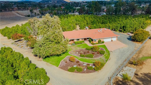 Very rare opportunity to own your very own single story private home on 12+ acres on a beautiful citrus orchard right in the heart of the famous Temecula Valley Wineries!!! The sellers have meticulously take care of custom home that offers a main home with approximately 4,500 sq. feet, 4 bedrooms 3.5 baths 3 fireplaces, wet bar, jetted tub, central vacuum, ceiling fans throughout, walk-in pantry and sunk in living room. The family room opens up with an oversize custom slider to a private deck that you can enjoy a glass of wine or your coffee within a serine picturesque setting. The ADU is well equipped with 1 bedroom, 1.5 baths, living room, private laundry and full kitchen. There are two additional storage sheds, 2 water meters, septic and zoned agricultural. Close to shopping, 15 FWY, wineries, Pala & Pechanga Casino, Old Town Temecula & offers Award winning Temecula Valley School District.