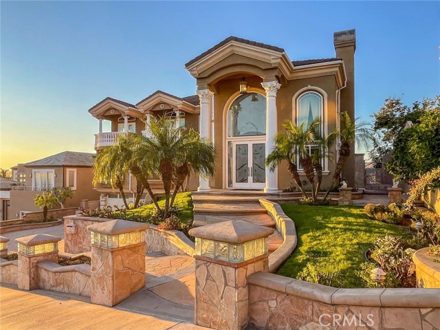 BREATHTAKING VIEW! An enchanting palatial estate boasts 5,790 Sq Ft of living space, 5 bedrooms & 6.5 baths including 4 en-suites and spectacular unmatched 270 degree VIEWS from sunrise to sunset. Located in the exclusive 24-hr guard gated community of FRIENDLY HILLS ESTATES! You ll be blown away by the panoramic vistas of the city lights, coastal horizon and rolling hills, stretching from LA, Orange County, all the way to Catalina Island! This architectural stunner captivates you from the moment you step through the soaring front columns and glass entry doors. The main level showcases a dramatic double-height foyer and a cascading wrought iron stairway w/ hand-crafted medallions. The living room presents exquisite floor-to-ceiling wooden columns which flank the fireplace and frame the huge mirror above. Formal dining has a wine bar, built-in cabinets & glass display shelves. Chef s kitchen includes a large center island, custom cabinetry, granite countertops, stainless steel appliances & walk-in pantry. The grand family room and breakfast nook overlook the astonishing views. Next to the 9-seat home theater is a guest bedroom & full bath. Off the hallway there s a powder room, indoor laundry & large built-in display cabinets. The home office has its own full bath, double glass doors, built-in cabinets, bookcases and desk. Down the hall is a downstairs en-suite w/ commanding views. Upstairs, there s a 2nd family room which opens to 2 additional en-suites. An enormous primary suite features jaw-dropping 270 degree views, a 3-sided fireplace, 2 retreats + an additional sitting area, a mirrored wet bar with built-in cabinets & fridge, and a luxury walk-in closet w/ custom wood organizers. Lavish master bath has a jacuzzi tub, an oversized steam-shower, double-sink vanity & a separate make-up vanity. The resort-style backyard includes an infinity pool, outdoor kitchen and BBQ for endless entertaining! The golden sunsets create a stunning and ever-changing backdrop in almost every room. Other highlights: attached 3 car garage & a driveway that accommodates 4-car spaces, 3 A/C units, central vacuum, and 4 sets of French doors which open onto 3 large balconies. Natural stone in all bathrooms w/ built-in stone framed mirrors. Crown molding soffit ceilings, chandeliers, engineered hardwood flooring, recessed lighting, and surround-sound system throughout. There are striking finishes and details at every turn; this amazing VIEW home has everything you ve dreamed of!